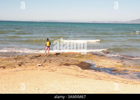Homme pêchant dans la baie de Palma depuis la plage des Meravelles, île de Majorque, Espagne Banque D'Images