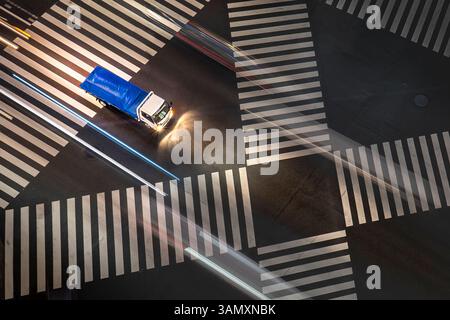 Vue aérienne d'un carrefour animé avec des stries légères et des croisements de zèbre la nuit, Yurakucho, Tokyo, Japon. Banque D'Images