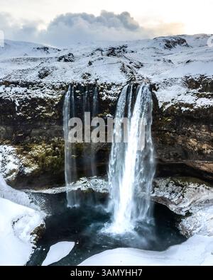 Vue aérienne de Seljalandsfoss, une belle cascade avec de la neige en hiver en Islande. Banque D'Images