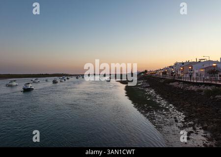 Coucher de soleil sur le pittoresque et charmant village de Cabanas, situé sur un lagon près du village historique de Tavira dans l'Algarve, Portugal. Banque D'Images