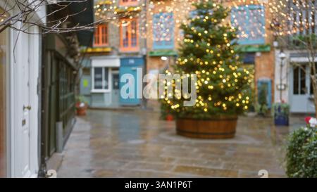 Sapin de Noël avec lumières dans une rue de londres floue de neal's yard pendant l'hiver mettant en valeur l'atmosphère festive et l'effet bokeh dans united kin d'angleterre Banque D'Images