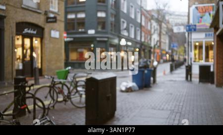 Vue imprenable sur la rue dans les sept cadrans de londres en automne avec effets bokeh avec boutiques et vélos floues le long du chemin pavé. Banque D'Images