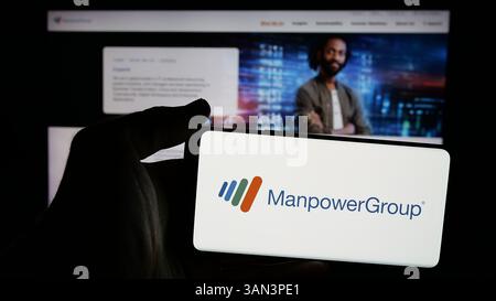 Stuttgart, Allemagne - 12-02-2024 : personne tenant un téléphone portable avec le logo de la société américaine de recrutement ManpowerGroup Inc sur l'écran Banque D'Images