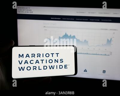Stuttgart, Allemagne - 12-02-2024 : personne tenant un smartphone avec le logo de la société américaine Marriott Vacations Worldwide Corporation sur l'écran Banque D'Images