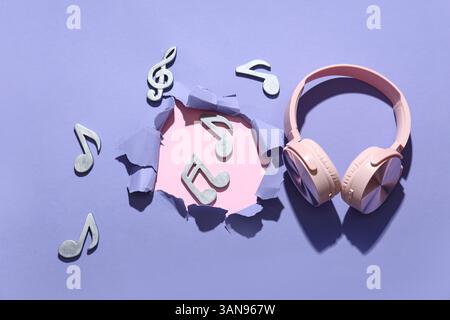 Casque avec notes sur fond violet Banque D'Images