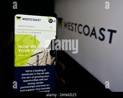 Allemagne. 04 mars 2025. Dans cette illustration photo, une personne tient un smartphone avec le site Web de la société INFORMATIQUE britannique Westcoast Limited sur l'écran devant le logo. (Photo timon Schneider/SOPA images/SIPA USA) *** strictement à des fins éditoriales *** crédit : SIPA USA/Alamy Live News Banque D'Images