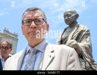 Neu Delhi, Inde. 15 avril 2025. Florian Herrmann (CSU), chef de la Chancellerie d’État bavaroise, se tient devant une statue surdimensionnée du Mahatma Gandhi lors d’un voyage en Inde de plusieurs jours du premier ministre bavarois Söder. Le premier ministre bavarois Söder ne peut pas participer au reste du voyage après être tombé malade et est remplacé par Herrman. Crédit : Peter Kneffel/dpa/Alamy Live News Banque D'Images