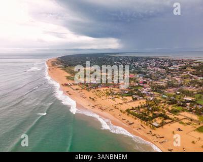 Vue aérienne de Keta, région de Volta, Ghana. Cette superbe image capture la vaste plage de sable et le paysage urbain, avec le lagon serein qui s'étend derrière la terre. Il met parfaitement en valeur la beauté naturelle et la géographie unique. Banque D'Images