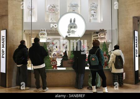 Paris, France. 18 mars 2025. Les gens s’attardent autour d’un magasin POP MART, une marque de culture pop chinoise, près du musée du Louvre à Paris, en France, le 18 mars 2025. POUR ALLER AVEC « Economic Watch : des jouets de créateurs aux créations d'IA, les fabricants de jouets chinois se mondialisent avec innovation, originalité » crédit : Zhang Baihui/Xinhua/Alamy Live News Banque D'Images