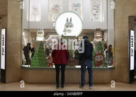 Paris, France. 18 mars 2025. Les gens s’attardent autour d’un magasin POP MART, une marque de culture pop chinoise, près du musée du Louvre à Paris, en France, le 18 mars 2025. POUR ALLER AVEC « Economic Watch : des jouets de créateurs aux créations d'IA, les fabricants de jouets chinois se mondialisent avec innovation, originalité » crédit : Zhang Baihui/Xinhua/Alamy Live News Banque D'Images
