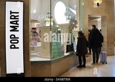 Paris, France. 18 mars 2025. Les gens s’attardent autour d’un magasin POP MART, une marque de culture pop chinoise, près du musée du Louvre à Paris, en France, le 18 mars 2025. POUR ALLER AVEC « Economic Watch : des jouets de créateurs aux créations d'IA, les fabricants de jouets chinois se mondialisent avec innovation, originalité » crédit : Zhang Baihui/Xinhua/Alamy Live News Banque D'Images