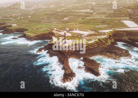 Vue aérienne de la belle côte avec des falaises, des vagues et des bananiers près du phare, Barlovento, Espagne. Banque D'Images