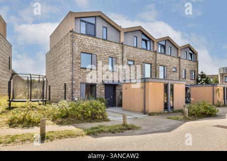 Un immeuble résidentiel contemporain au design épuré, entouré de verdure et d'un paysage bien entretenu. Idéal pour mettre en valeur l'architecture moderne. Banque D'Images