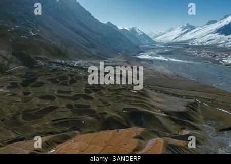 Vue aérienne de la campagne près de la ville Kaza le long de la rivière Spiti dans la province de l'Himachal Pradesh avec montagne enneigée en arrière-plan, Inde. Banque D'Images
