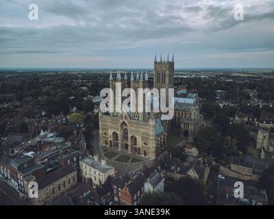 Vue aérienne de la cathédrale de Lincoln entourée de toits et d'arbres sous un ciel nuageux, Lincoln, Royaume-Uni. Banque D'Images