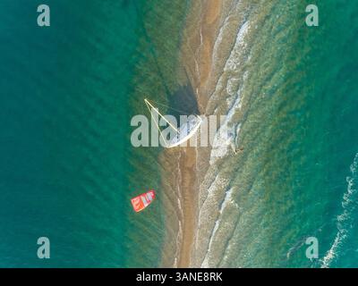 Vue aérienne de la personne kitesurf autour d'un voilier échoué dans le golfe de Patras, Grèce. Banque D'Images
