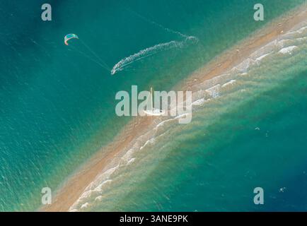 Vue aérienne de la personne kitesurf autour d'un voilier échoué sur un banc de sable dans le golfe de Patras, Grèce. Banque D'Images