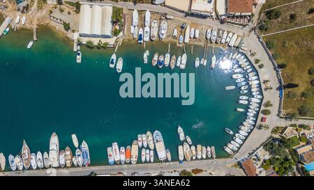 Vue aérienne de nombreux bateaux privés dans le petit port dans la baie de Nisi, Grèce. Banque D'Images
