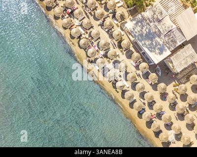 Vue aérienne de la plage avec parasols de paille sur la rive de l'Achaia, Grèce. Banque D'Images