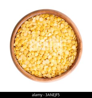 Lentilles jaunes dans un bol en bois. Graines séchées d'une variété de Lens esculenta, une légumineuse de fruits de couleur petits, ronds et jaunes. Banque D'Images