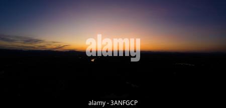 Vue aérienne panoramique du coucher de soleil de silhouette, derrière les montagnes, Zagreb, Croatie. Banque D'Images