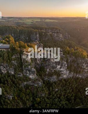 Vue aérienne du pont de Basteibrucke sur l'Elbe avec les rochers et les arbres environnants au lever du soleil, Basteibrucke, Allemagne. Banque D'Images