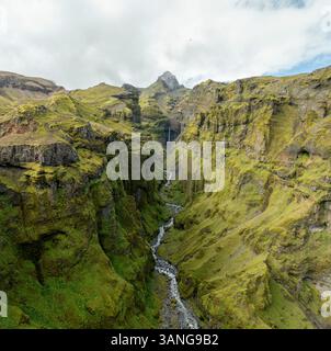 Vue aérienne du canyon de mulagljufur avec des montagnes majestueuses et une cascade sereine, Oraefasveit, région sud, Islande. Banque D'Images