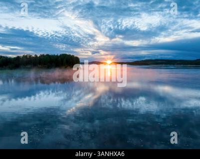 Vue aérienne du coucher de soleil sur le lac calme pendant le soleil de minuit à Overtornea, Suède. Banque D'Images