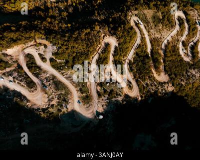 Vue aérienne du pittoresque lac Bovilla avec route de montagne sinueuse entourée d'une forêt sereine, Herraj, Tirana, Albanie. Banque D'Images