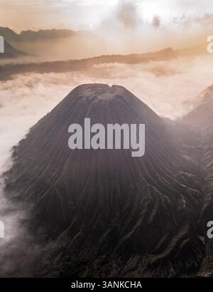 Vue aérienne du majestueux volcan Mont bromo avec de la fumée et un paysage à couper le souffle au coucher du soleil, Tosari, Indonésie. Banque D'Images