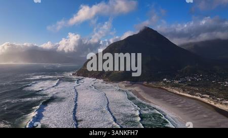 Vue aérienne de Chapmans Peak côtier avec des montagnes majestueuses, des nuages sereins et des vagues, Noordhoek, Cap occidental, Afrique du Sud. Banque D'Images