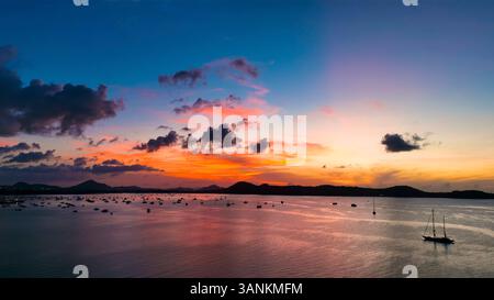 Vue aérienne du lever de soleil serein sur l'océan avec ciel coloré et bateaux, île de Phuket, Thaïlande. Banque D'Images