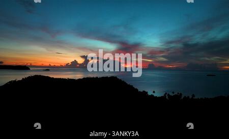 Vue aérienne du lever de soleil serein sur l'île avec ciel tropical et océan calme, Fidji. Banque D'Images
