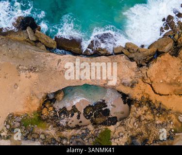 Vue aérienne du Pont naturel le long de la côte avec des falaises dans la baie d'Andicuri, Paradera, Aruba. Banque D'Images