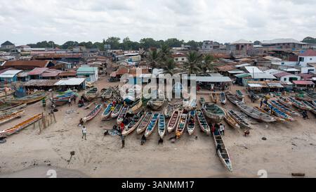 Vue aérienne d'un marché aux poissons animé avec des bateaux traditionnels en bois et des gens, Tujering, Gambie. Banque D'Images