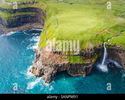 Vue aérienne de la cascade de Múlafossur se terminant sur la mer Atlantique Nord, île Féroé. Banque D'Images