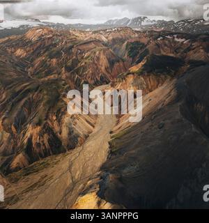Vue aérienne des formations rocheuses volcaniques colorées et des montagnes escarpées dans une vallée à couper le souffle, Landmannalaugar, région du Sud, Islande. Banque D'Images