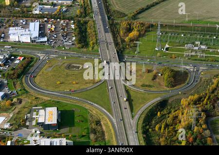 Vue aérienne d'une intersection animée avec des véhicules et des bâtiments entourés de verdure et de champs, Leipzig, Saxe, Allemagne. Banque D'Images