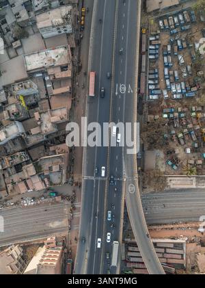 Vue aérienne de la route de jonction très fréquentée avec une gare routière et des voies ferrées entourées de bâtiments urbains, Gendaria, Dhaka, Bangladesh. Banque D'Images