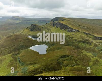 Vue aérienne de la majestueuse montagne Quiraing et de la vallée verdoyante sereine avec de l'eau, Portree, Écosse. Banque D'Images