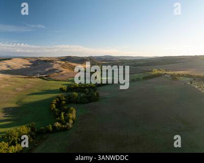 Vue aérienne de belles collines et champs pittoresques sous un ciel serein, San Quirico d'Orcia, Italie. Banque D'Images