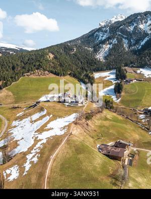 Vue aérienne de l'église Santa Maddalena et village de montagne dans le Val di Funes, Dolomites, Tyrol du Sud, Italie. Banque D'Images