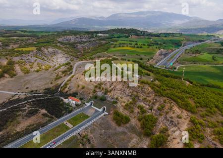 Vue aérienne de l'autoroute traversant le tunnel entre les montagnes Taxiarchis, Macédoine occidentale, Grèce. Banque D'Images