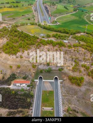 Vue aérienne de l'autoroute traversant le tunnel entre les montagnes Taxiarchis, Macédoine occidentale, Grèce. Banque D'Images