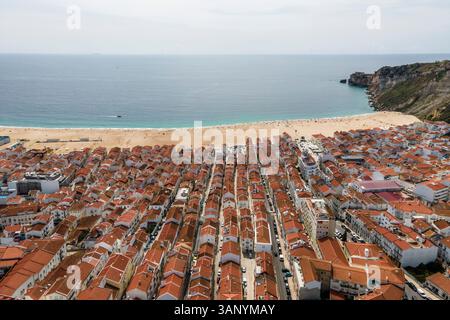 Vue aérienne de Nazaré, une petite ville le long de la côte de l'océan Atlantique avec une grande plage en été, district de Leiria, Portugal. Banque D'Images
