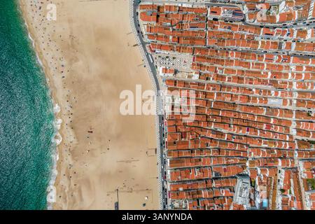 Vue aérienne de Nazaré, une petite ville le long de la côte de l'océan Atlantique avec une grande plage en été, district de Leiria, Portugal. Banque D'Images