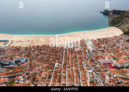 Vue aérienne de Nazaré, une petite ville le long de la côte de l'océan Atlantique avec une grande plage en été, district de Leiria, Portugal. Banque D'Images