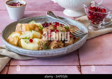 Boulettes de viande suédoises traditionnelles en sauce crémeuse avec pommes de terre bouillies et airelles Banque D'Images