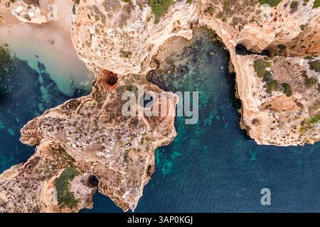 Vue aérienne de Praia dos Pinheiros, une belle plage paradisiaque le long de la côte avec des falaises pittoresques près de Ponta da Piedade, Lagos, région de l'Algarve, Portug Banque D'Images