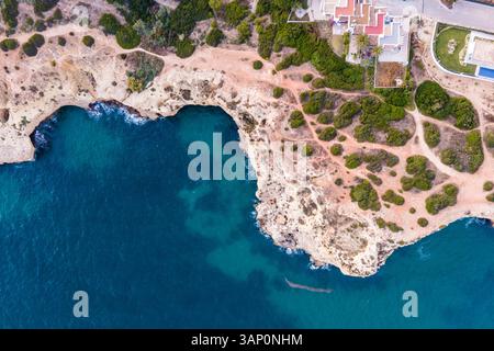 Vue aérienne de la côte sauvage avec des falaises près du canton de Carvoeiro pendant une belle matinée d'été, Carvoeiro, Algarve, Portugal. Banque D'Images